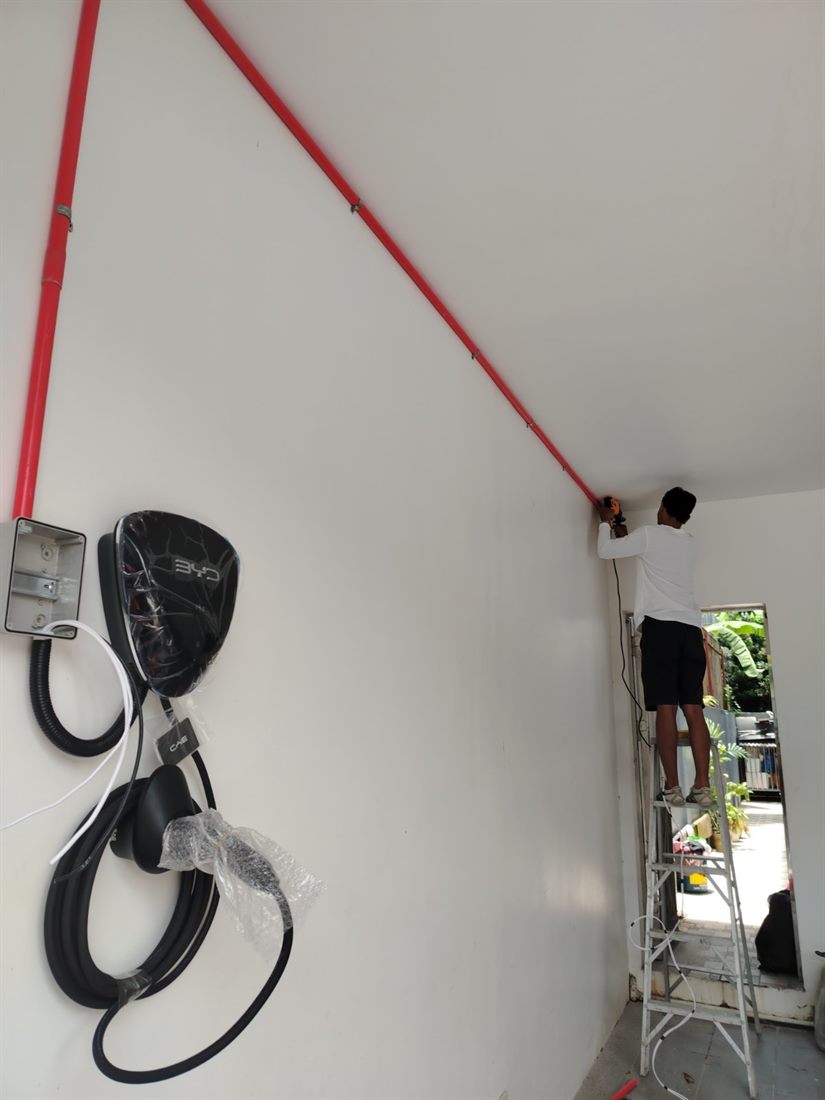 Brothers Energy technician installing a BYD wall charger on site in the Philippines